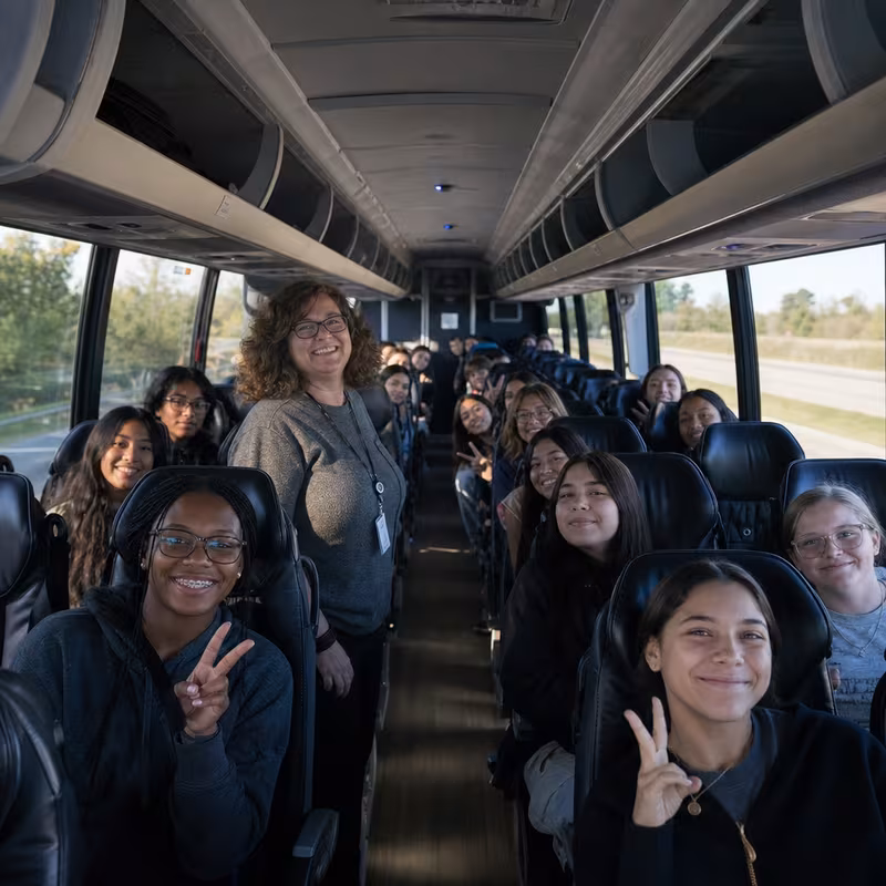 Group boarding a white charter bus for School Transportation transportation in Gilbert