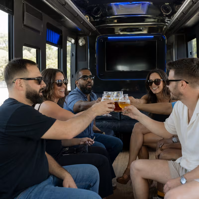 Group boarding a white charter bus for Winery & Brewery Tour Transportation transportation in Gilbert